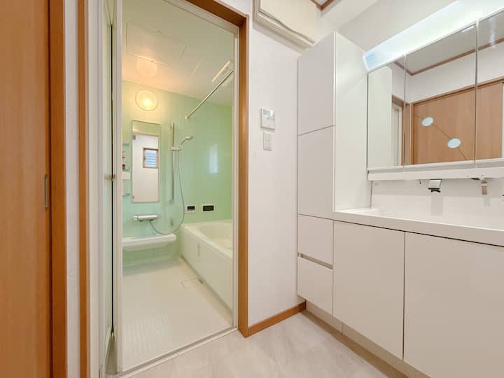 乾湿分離された洗面エリア。バスタブとシャワーの両方を備え、お客様の入浴ニーズを満たします。お客様ごとにバスタブを清掃し、安心してご宿泊いただけるようにしています。シャンプーとシャワージェルはホテルと同じものです。