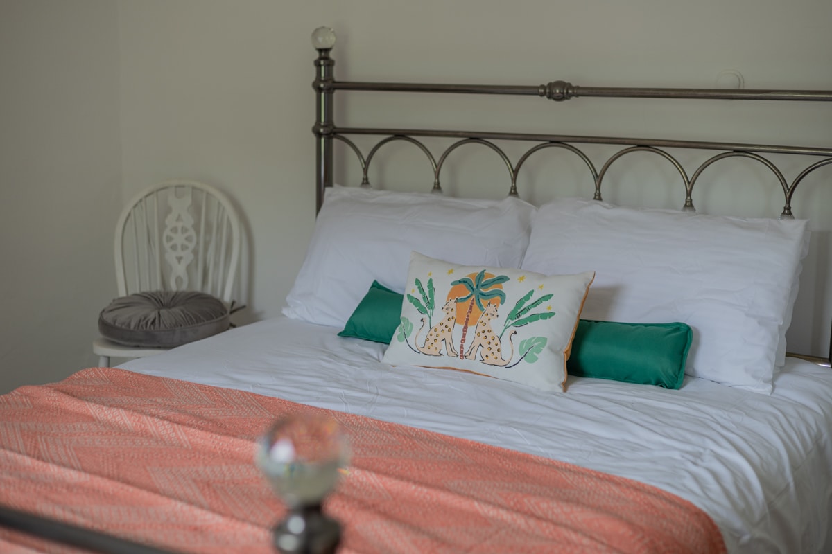 Dhomë gjumi e ndriçuar dhe komode me ngjyra të buta dhe shtroja ftuese