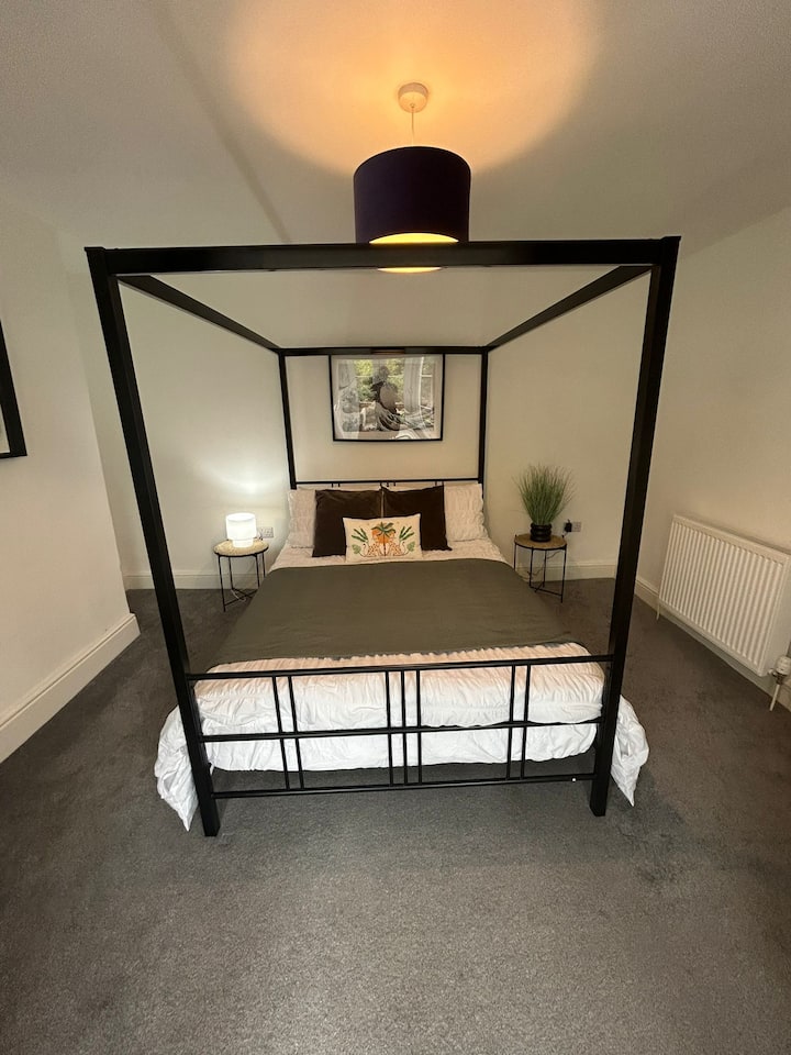 მსუბუქი საძინებელი თეთრი ლითონის საწოლითა და სუფთა, ჰაეროვანი დეკორით.