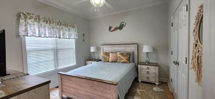 Dormitorio de invitados en la planta principal con cama tamaño queen, TV y un armario de gran tamaño.