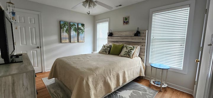 Dormitorio de invitados en la planta superior con cama tamaño queen, TV y vestidor