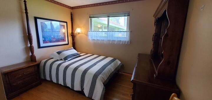 غرفة نوم أنيقة مع لحاف مخطط وإطار جداري مزخرف