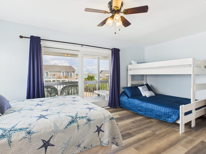This secondary upstairs bedroom features a Queen bed plus a Twin XL over Queen bunk bed. Also includes a private covered outdoor deck.