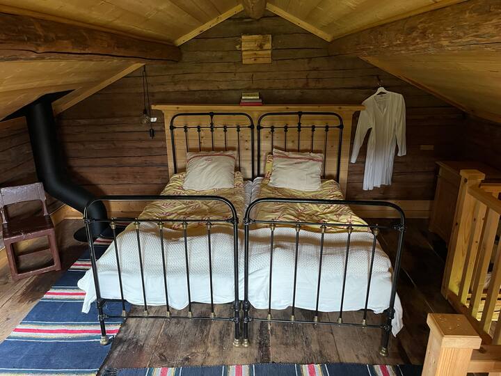 Горниот кат на Härbret со брачен кревет и греење од печката на долниот кат. 