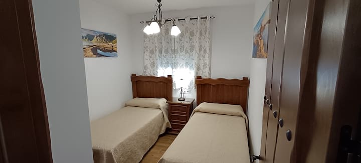 2 single beds of 0.90 m x 1.95 m with headboard and 1 rustic style solid wood table.