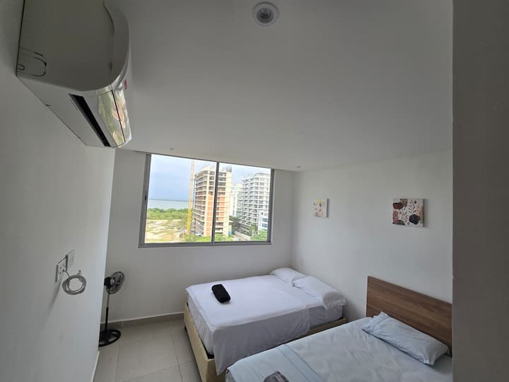 Izba s pohodlnými posteľami, prenosným ventilátorom a klimatizáciou pre sviežosť