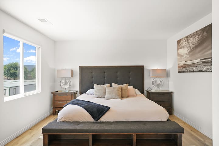 Amplio dormitorio principal ubicado en el segundo piso con gran baño privado en suite. Cama tamaño king. La habitación incluye una estación de trabajo, bicicleta de pelotón y área de estar. 