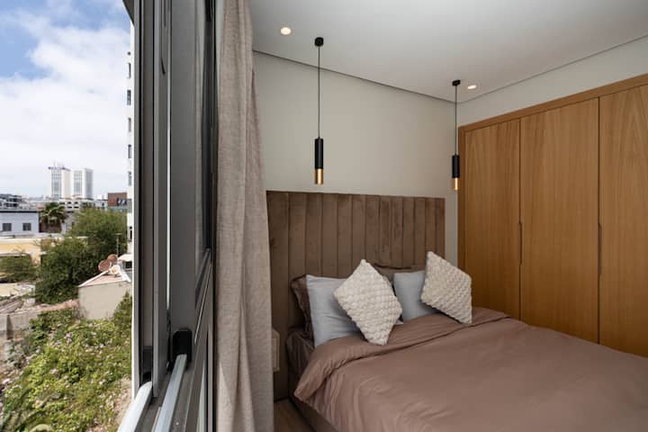 Descanse en una habitación luminosa con una cómoda cama grande, ropa de cama de calidad, almacenamiento integrado y vistas despejadas de la ciudad. Ambiente relajante garantizado.