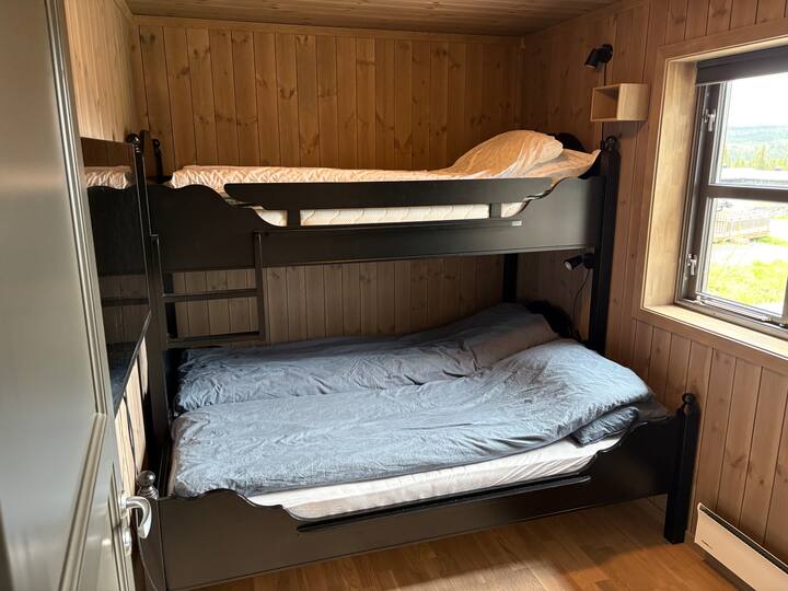 Spavaća soba 1. Krevet na kat s krevetom na visini od 90 cm i krevetom na visini od 150 cm.  U ovoj spavaćoj sobi nalazi se zaseban pametni televizor. 