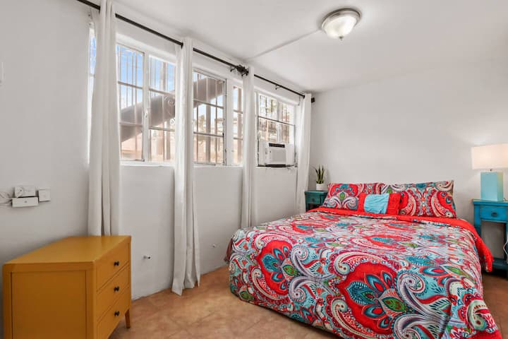 Dormitorio con ventanas para ventilación y mesa auxiliar