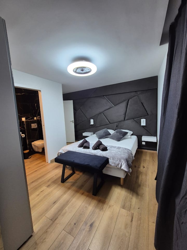 Gemütliches Zimmer mit Leselampen, dimmbarem Kronleuchter und leisem Ventilator.