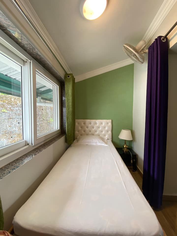 Un dormitorio individual en el entrepiso con una cama y una mesita de noche. Los baños tendrán que compartirse con los dormitorios principales en el primer piso. 