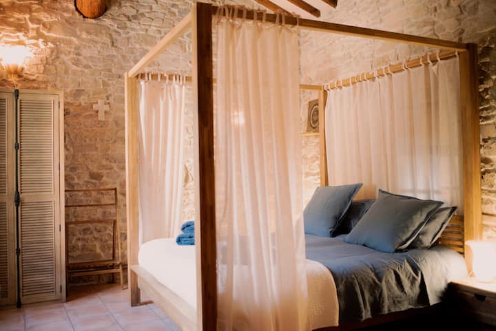 La habitación principal Céleste le da la bienvenida bajo hermosas piedras a la vista, con una cama con dosel tamaño king para noches de absoluta comodidad.