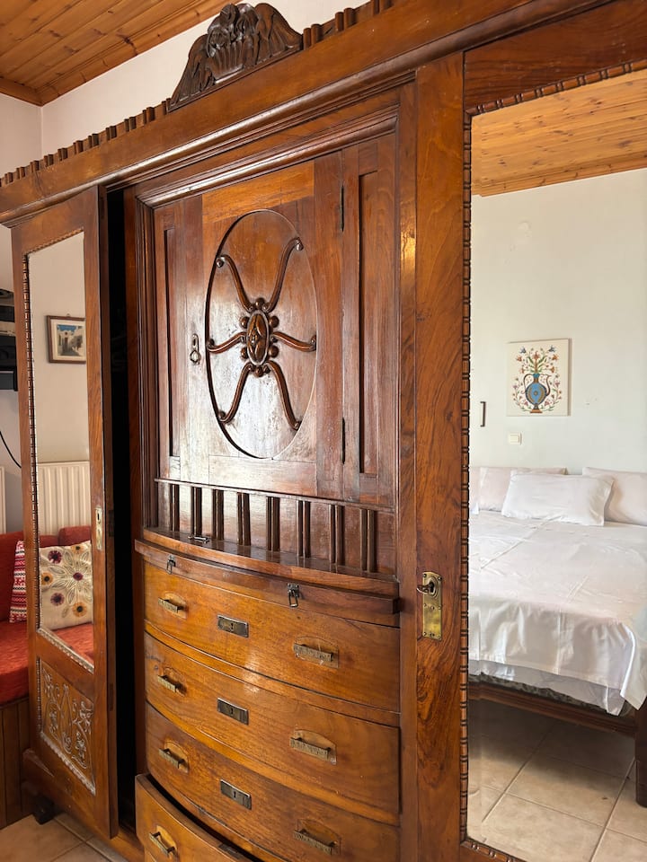 U spavaćoj sobi dominira prekrasan, izrezbaren antikni ormar.