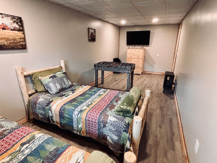 Walk out basement with foosball, TV and gaming console.