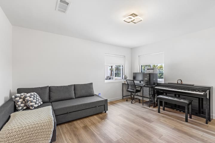 这间多功能客房配备沙发床、工作区，甚至还有一架钢琴，非常适合在住宿期间放松身心、远程工作或享受音乐。