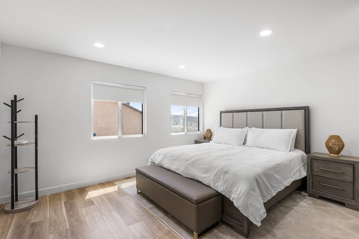 在这间宁静的主卧室中，您可以在自然光中醒来，配备豪华加大双人床、柔和的色调和温暖的木地板。