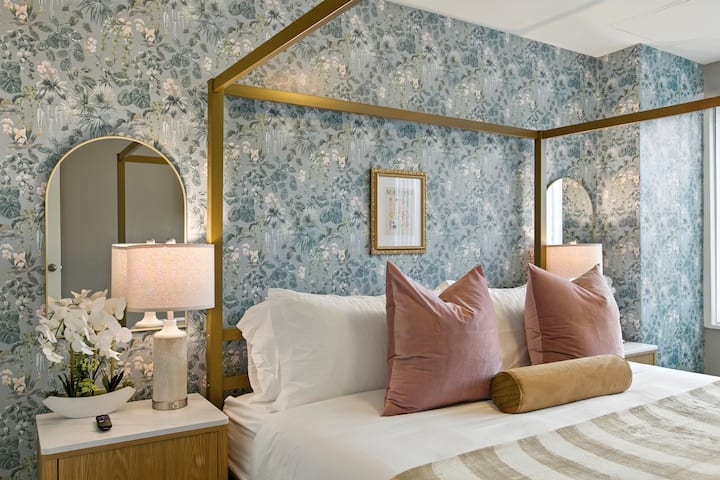 PICHA YA KARIBU YA MAUA YA MSANIFU! Kanopi ya dhahabu, karatasi ya ukuta ya mimea, mito ya velvet ya blush, na matao ya kitanda ya kuchongwa yanathibitisha kila inchi iko tayari kwa picha, mandharinyuma kamili kwa ajili ya majarida ya asubuhi au picha za kupendeza!