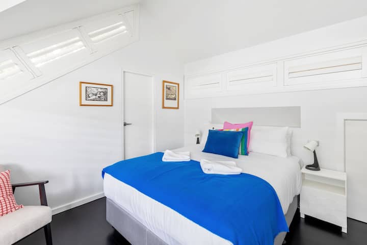 La deuxième chambre à l'étage supérieur est dotée d'un grand lit avec des touches de couleur vives, des draps frais et une atmosphère sereine.