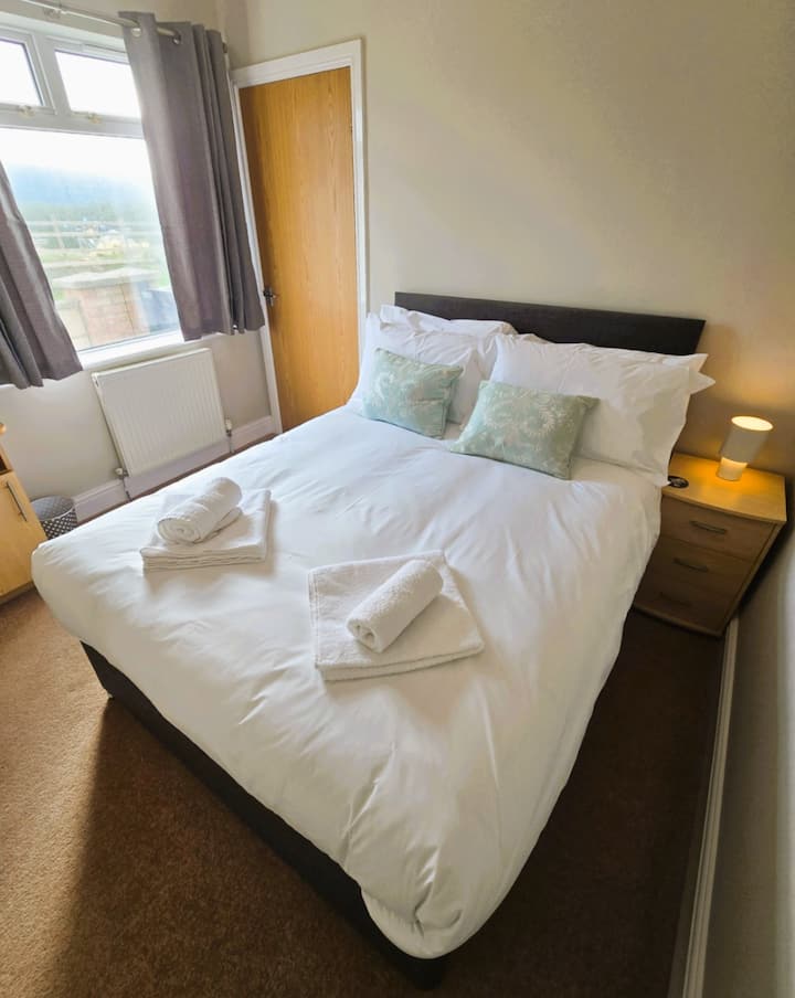 楼下双人卧室，带衣柜和边桌。
楼下淋浴间，旁边有洗脸池和马桶。