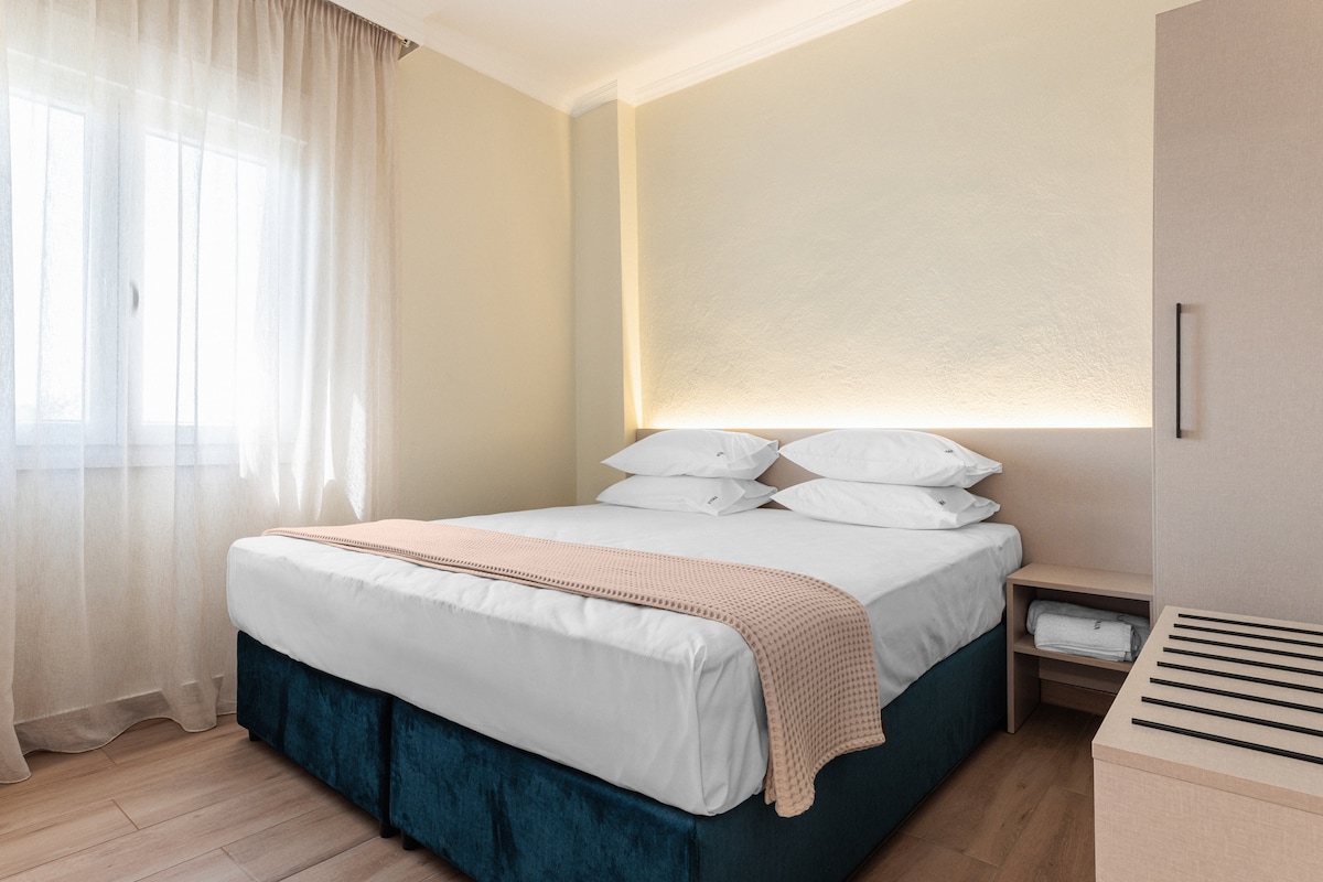 Спална соба со брачен кревет (широк 150-179 см) и телевизор со рамен екран.