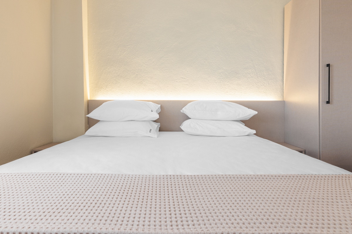 Спална соба со брачен кревет (широк 150-179 см) и телевизор со рамен екран.