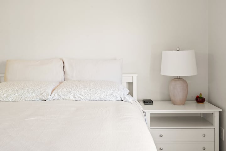 Të ftojmë nga afër dhomën e gjumit me një krevat të rehatshëm, komodinë dhe abazhur. Ndriçimi i ngrohtë krijon një atmosferë relaksuese, të përsosur për zgjimin e mëngjesit.