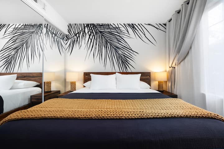 Moderná spálňa s manželskou posteľou, výrazné umelecké diela na stene