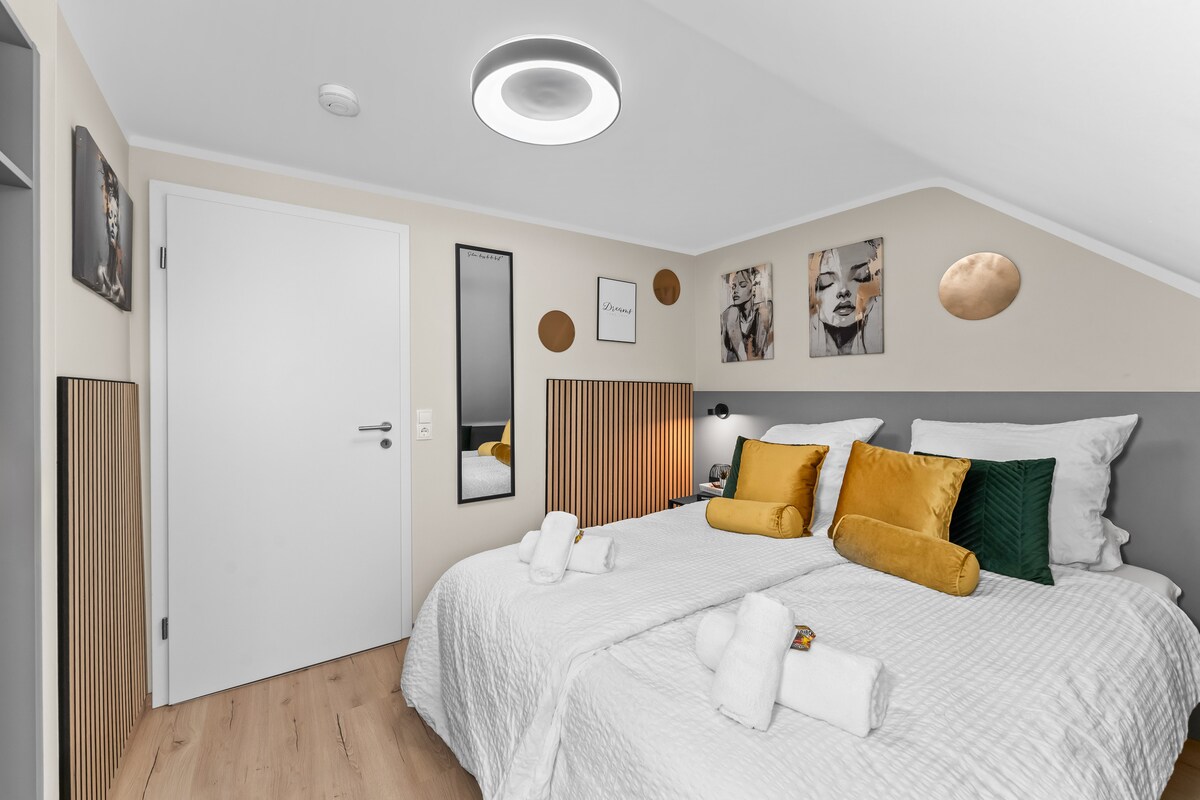 Een stijlvol ingerichte slaapkamer met een hoogwaardig boxspringbed nodigt je uit om uit te schakelen en te ontspannen – je eigen retraite.