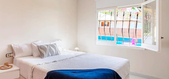 La camera da letto principale ha un letto matrimoniale, una lampada da soffitto con ventilatore e tende che garantiscono un'oscurità totale per un riposo ristoratore. Dalla finestra si gode di una vista diretta sulla piscina