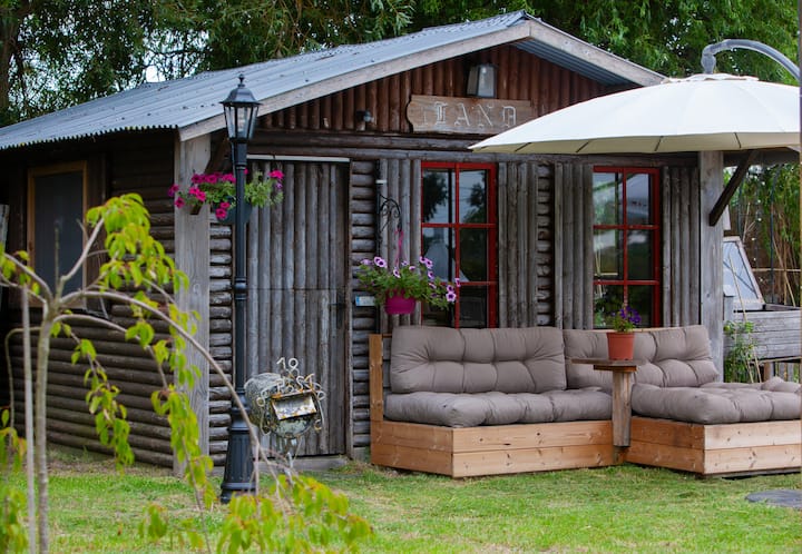 בקתת עץ מקסימה מוקפת בנופי גינה. האורחים יכולים להירגע באזור הישיבה החיצוני, ליהנות מקפה בבוקר או להירגע באווירה הכפרית השלווה במרחק צעדים ספורים מהבריכה ומהמרפסת.