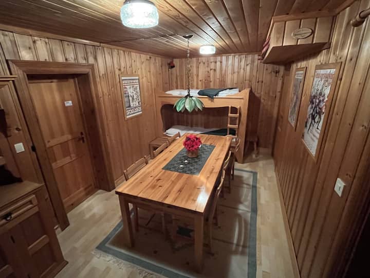Anteroom to the large living room with 2 beds and a larger dining area.