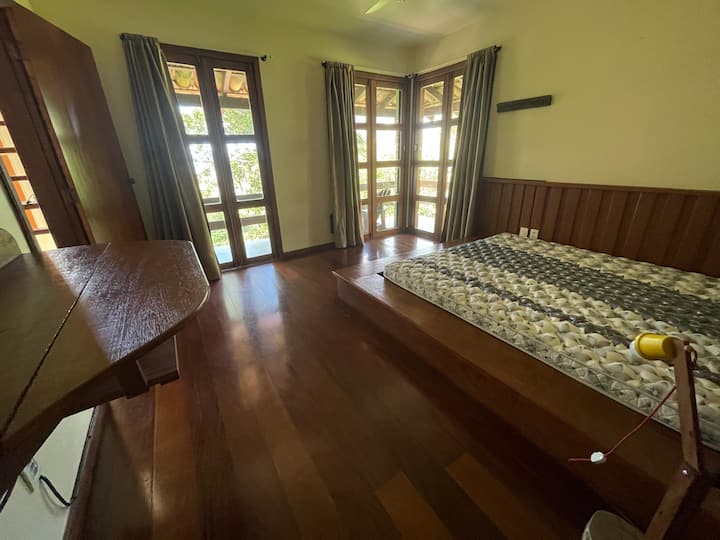 Quarto 2 com cama grande e madeira