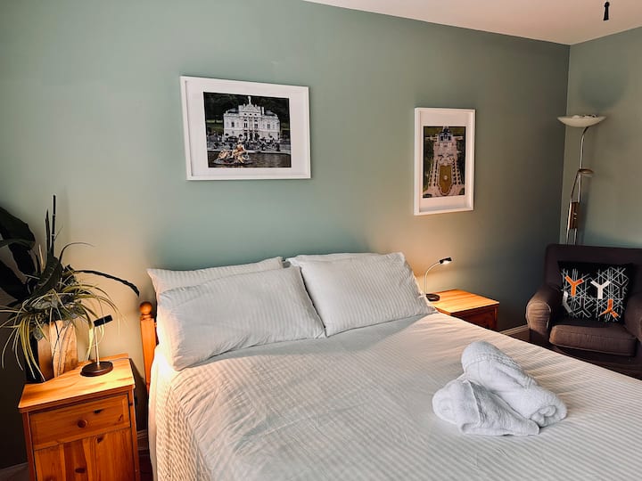 غرفة نوم في الطابق السفلي مع منطقة جلوس مريحة.