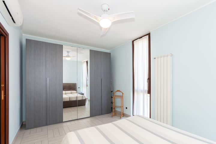 Chambre lumineuse avec grande armoire miroir, lit double et accès direct au balcon. Équipée de la climatisation et d’un ventilateur pour un confort maximal en toute saison.