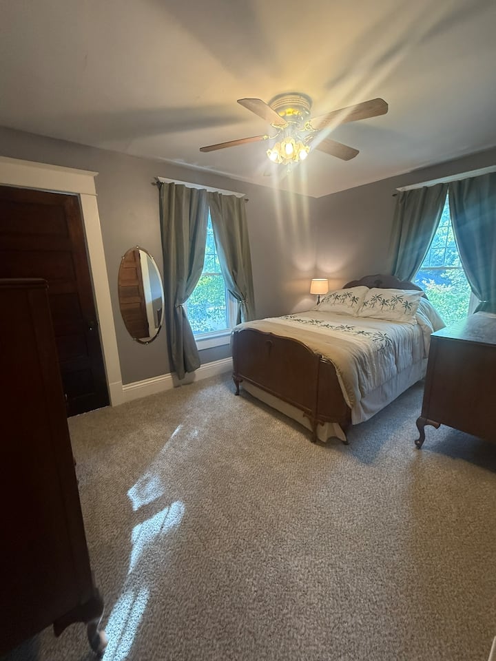 Full size bed met twee dressoirs, kast en bijzettafel met nachtlampjes met USB-poorten.