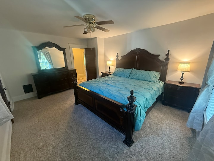 Grote slaapkamer met kingsize bed en inloopkast en grote spiegelkast.  Bedverlichting met USB-poorten. Airconditioner voor het raam aanwezig tijdens de warmere maanden.