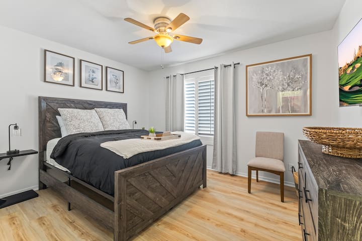 Брачна спална соба со премиум постелнина, плакар и телевизор на ѕид со ROKU и полнење покрај креветот. 