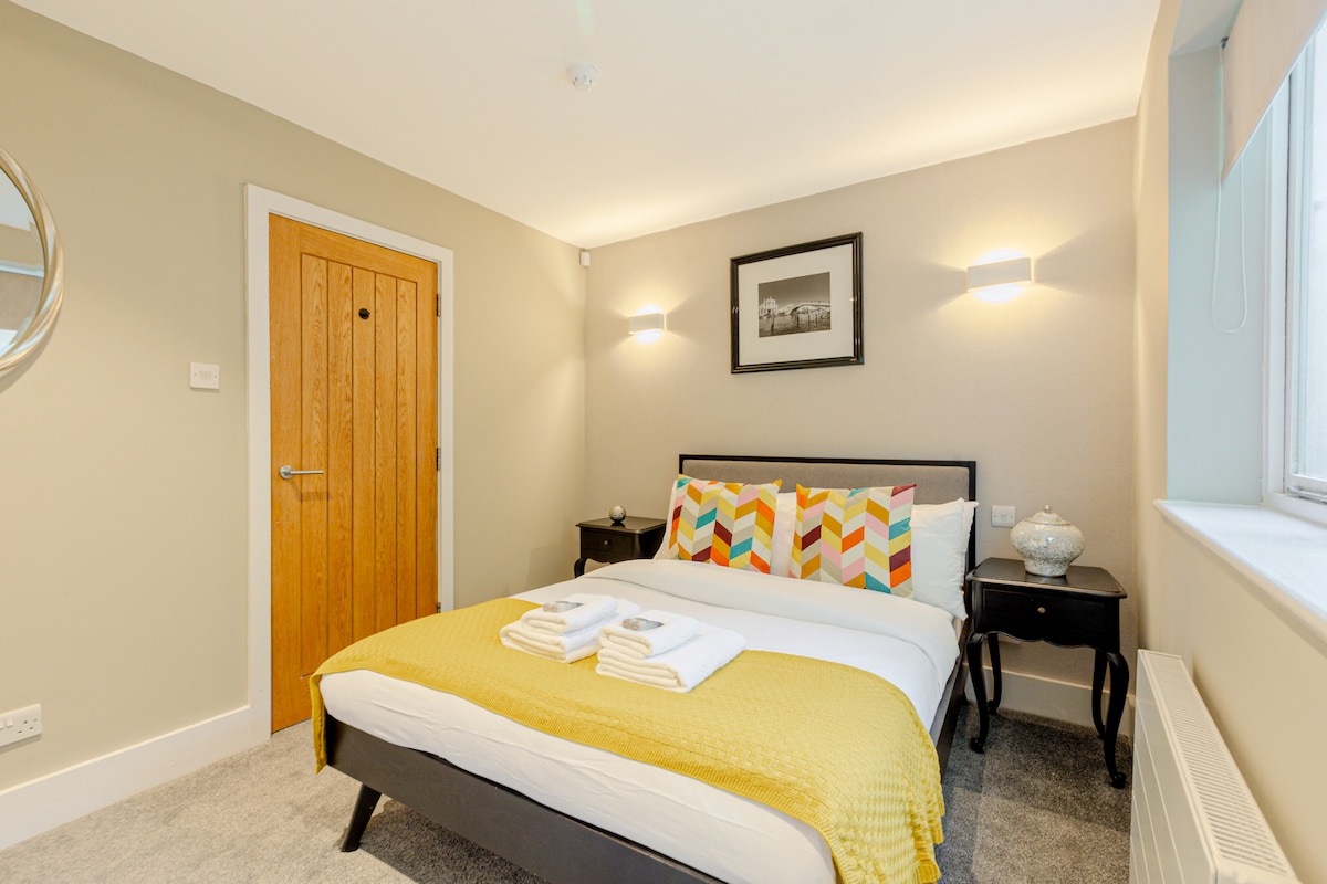 Una acogedora habitación doble con tonos cálidos y amplio espacio de almacenamiento, diseñada para ofrecer comodidad y practicidad durante estancias prolongadas.

