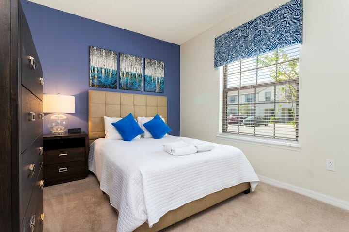 - Lichte slaapkamer met queensize bed, natuurlijk zonlicht en een prachtig gelaagd decor  
- Frisse blauwe kunstwerken passen perfect bij het warme, ontspannende beddengoed  
- Comfortabele retraite dicht bij de beste attracties en parken van Orlando  
