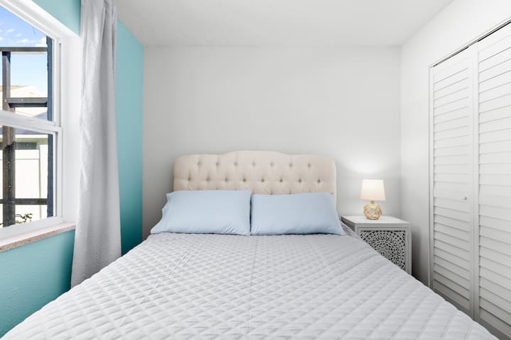 Manželská posteľ s prešívaným čelom s výhľadom na bazén s veľkou skriňou a stojanom na batožinu pripraveným na váš príchod 