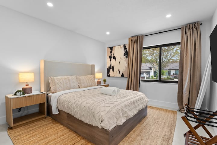 Matandiko laini, mwanga wa joto na mapambo ya amani hufanya chumba hiki cha kulala kiwe mahali pazuri pa kupumzika.
