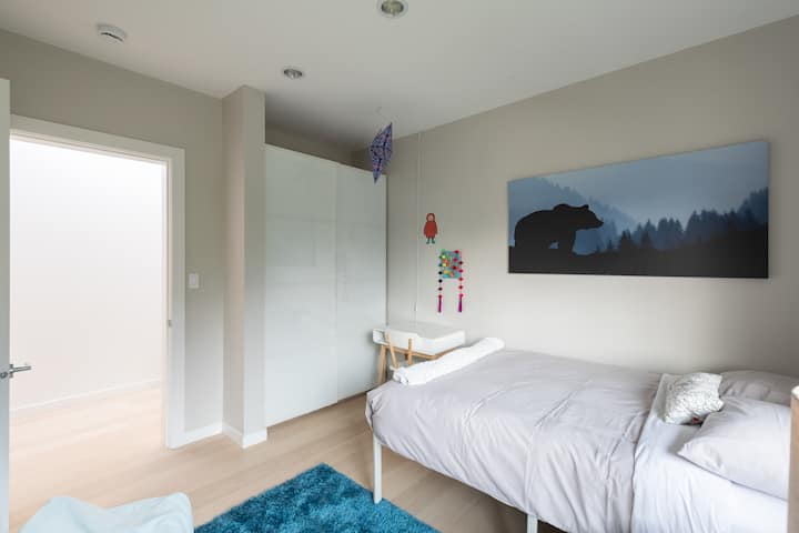Dormitorio con cama matrimonial y puerta corredera que conduce a un baño completo compartido entre los dormitorios 2 y 3