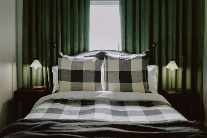 La pared decorativa de la cortina de terciopelo verde funciona como persianas opacas para una noche de descanso adicional, y siempre tendrás acceso a almohadas de espuma viscoelástica trituradas adicionales, una manta de vellón adicional y portaequipajes y perchas dentro del armario. 