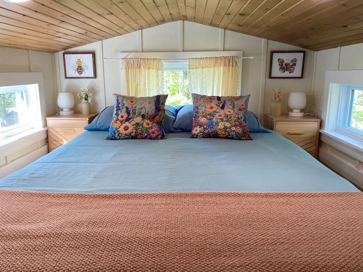 Cama tamaño queen acogedora para dos personas en el loft. Hay ropa de cama adicional en los cubículos.