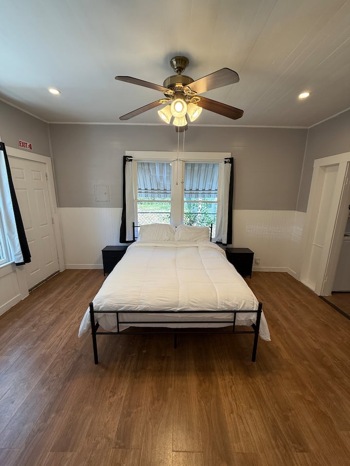 mwonekano wa mbele wa kitanda katika chumba cha kulala chenye stendi 2 zilizo na sehemu ya ziada ya kuhifadhi 