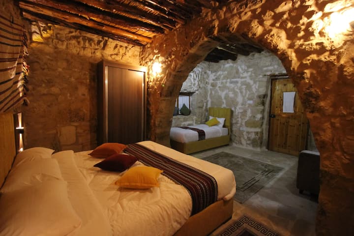 Trojlôžková izba pozostávajúca z manželskej postele, samostatnej postele, pohovky, šatníka, zrkadla a klimatizácie. Nachádza sa na prízemí. Budova je postavená z kameňa, ktorý v zime poskytuje teplo a v lete chlad pre pohodlný a jedinečný pobyt. 