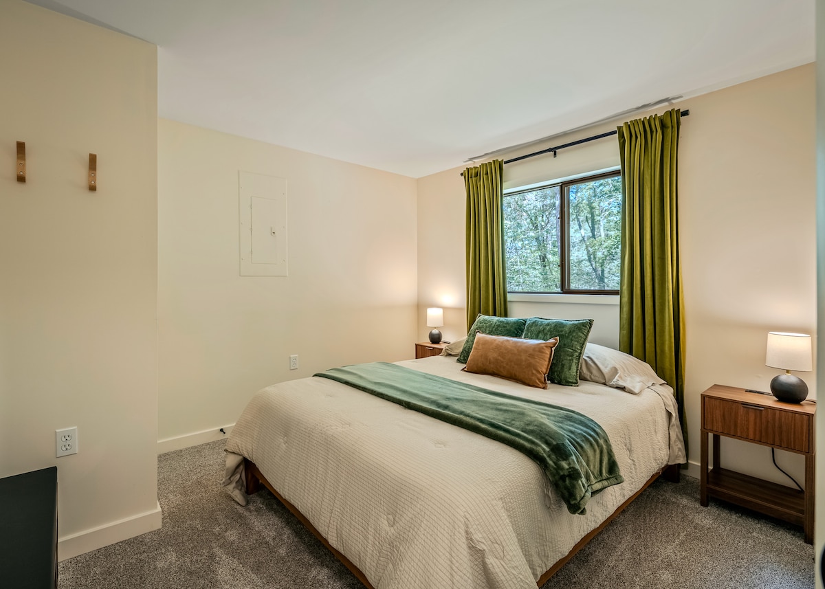 El dormitorio 3 tiene una cama tamaño queen, lámparas de noche y un baño en el pasillo justo afuera de la puerta.