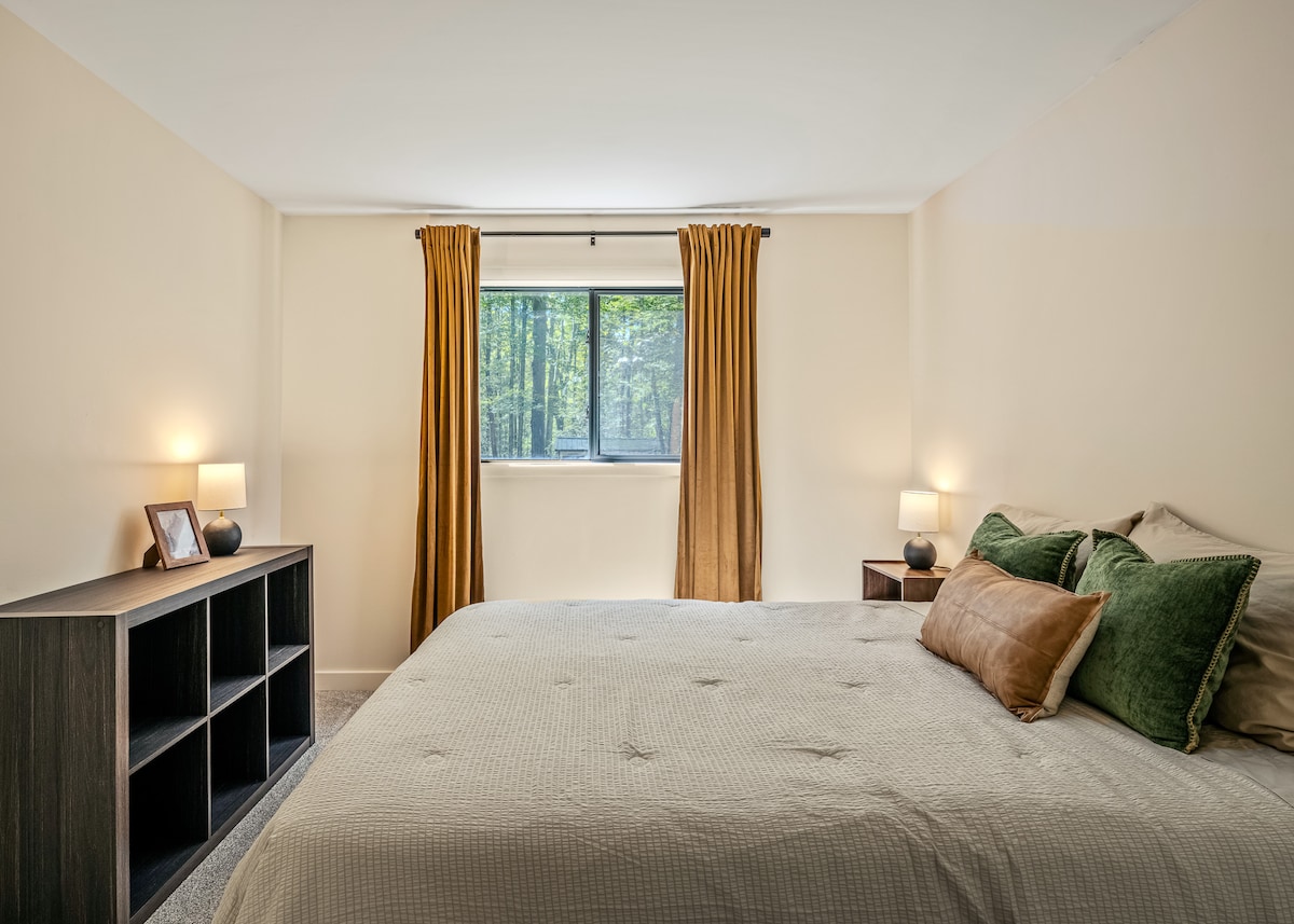 El dormitorio 2 tiene una cama tamaño queen, un cubo para tu ropa y otras posesiones, y un baño en el pasillo justo afuera de la puerta.