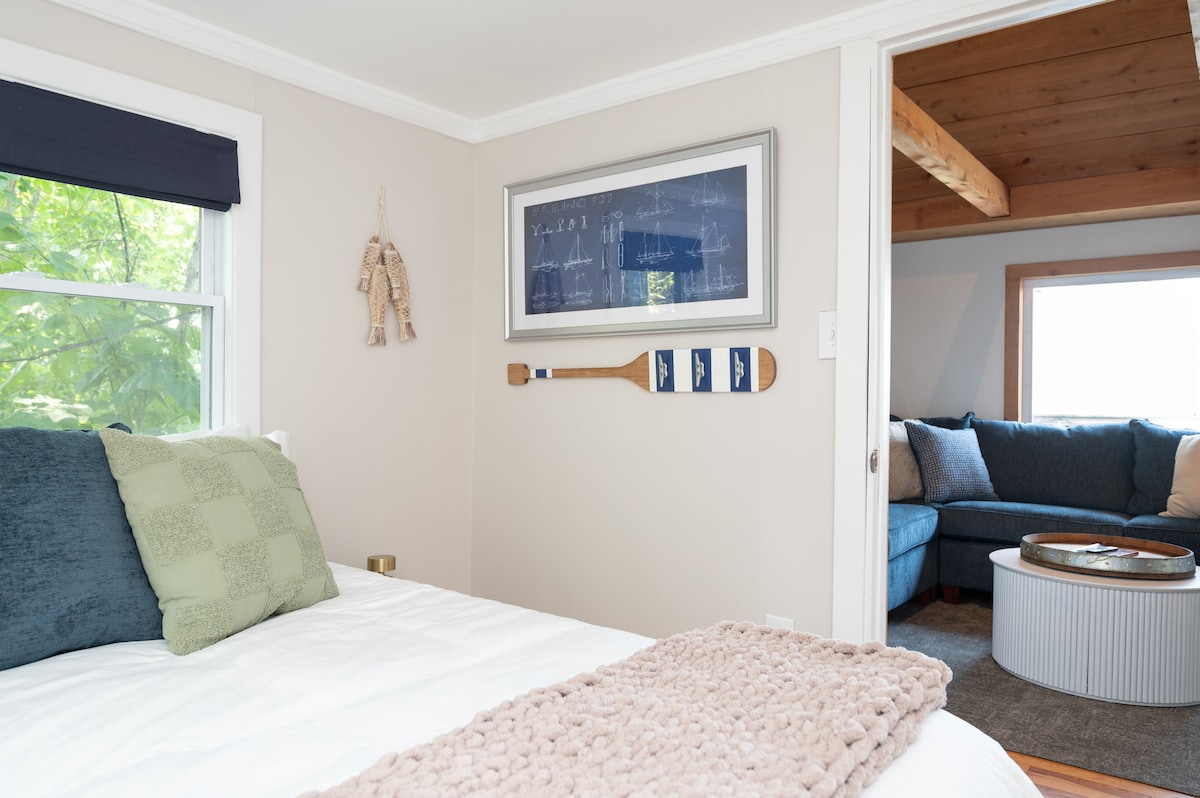 Queen size bed with bedside lamps and charging cubes on either side of the bed. 